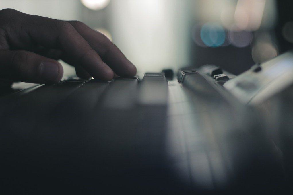 Hand typing on a keyboard during video game development.